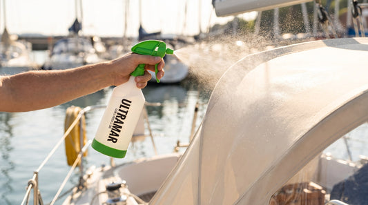 Ultramar Sprayhood & Tent Protector wordt op een donkerblauwe bootkap gesproeid in een jachthaven
